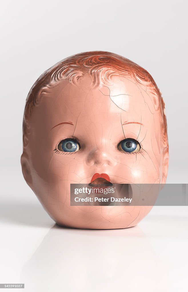 Damaged and cracked dolls face with eyes open