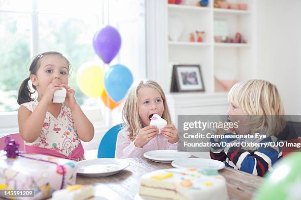 children eating cake at birthday party - david swallow stock pictures, royalty-free photos & images