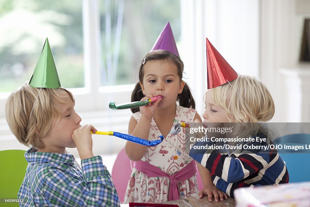 Children blowing party horn blowers