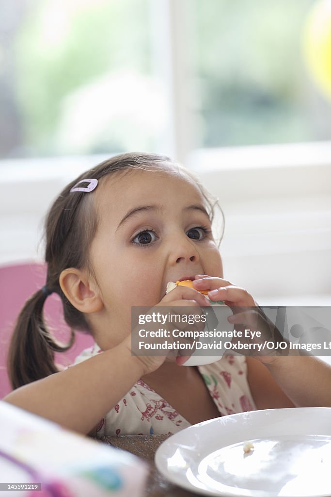 Girl (3-4) eating birthday cake