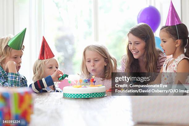 girl blowing out candles on birthday cake - all age party stock pictures, royalty-free photos & images