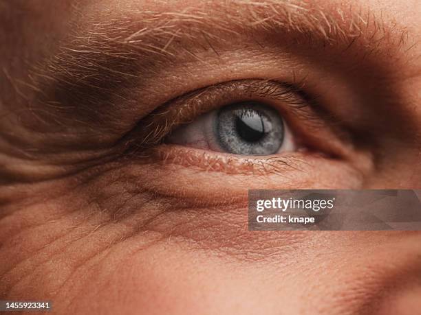 eye - macro skin and face detail with wrinkles on mature man - iris eye stock pictures, royalty-free photos & images