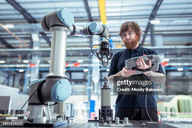 uk, burnley, operator with robot vehicle in battery research facility - roboter industrie stock-fotos und bilder