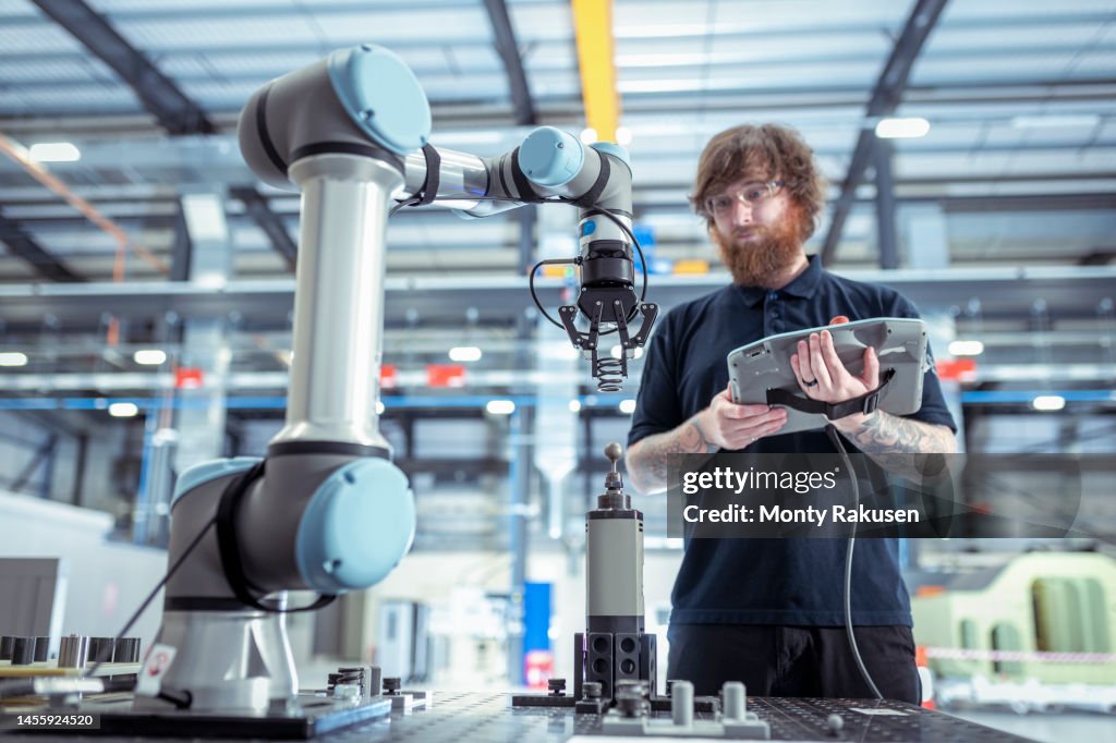 UK, Burnley, Operator with robot vehicle in battery research facility