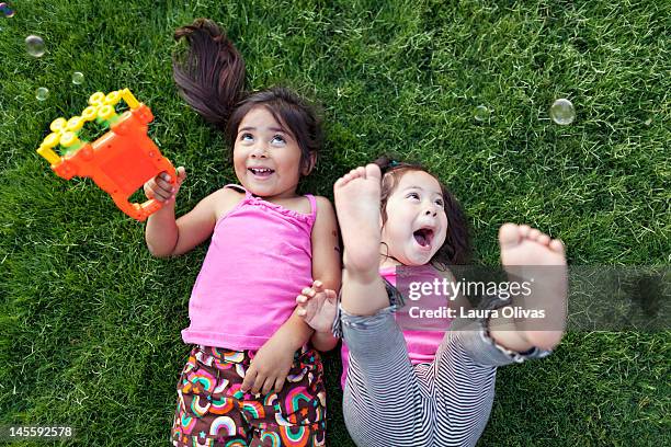 toddler girls playing with bubbles - bubble wand foto e immagini stock