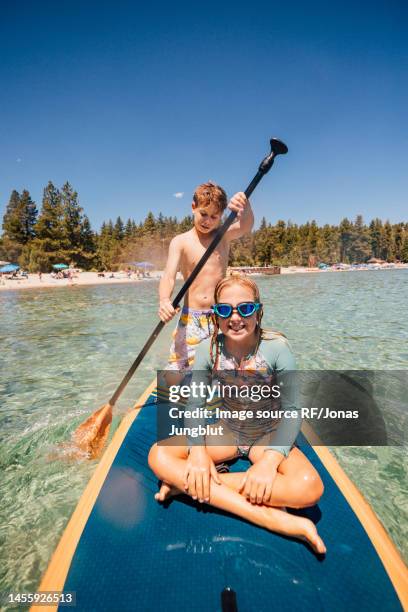 usa, california, brother and sister paddleboarding on lake tahoe - preteen girl no shirt stock pictures, royalty-free photos & images