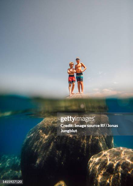 usa, california, boys standing on boulder in lake tahoe - 11 loch stock pictures, royalty-free photos & images