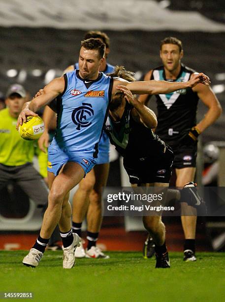 Broak McLean of Blues kicks the ball forward while being challenged by Justin Westhoff of Power during the round 10 AFL match between the Port...