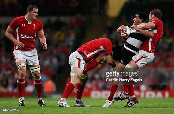 Mils Muliaina of the Barbarians is tackled by Alun Wyn Jones and Josh Turnball of Wales during the international match between Wales and The...