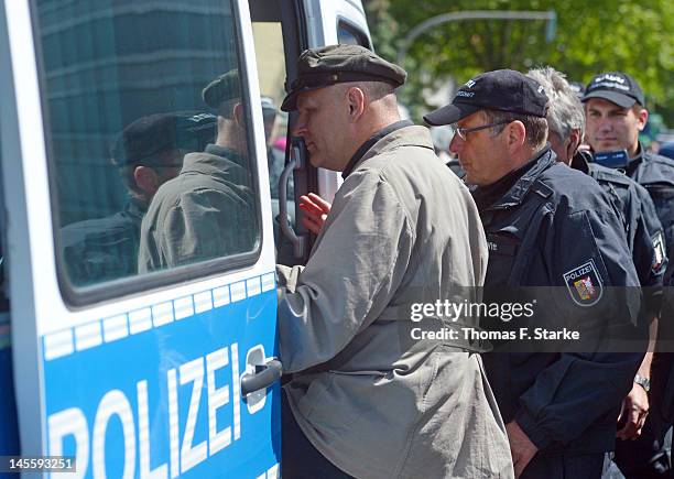 Right wing activist Thomas Wulff follows police officers in a car during a march by neo-Nazis on June 2, 2012 in Hamburg, Germany. Thousands of...