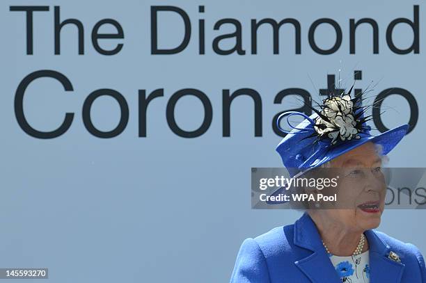 Queen Elizabeth II prepares to present the trophies for the winning horse St Nicholas Abbey in the Diamond Jubilee Coronation Cup race on Derby Day...