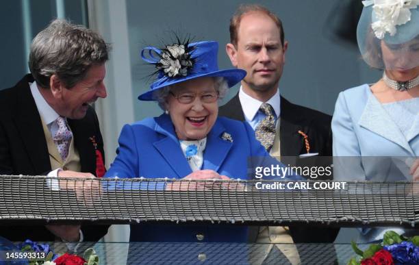 Britain's Queen Elizabeth II standing next to Prince Edward, Earl of Wessex smiles from the royal balcony as she looks down on the winning horse in...
