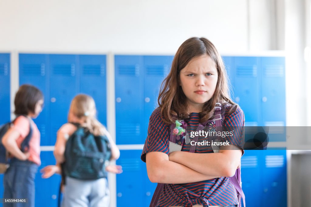 Angry girl standing at school corrior