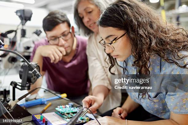 college instructor assisting electrical engineering students - science and technology class stock pictures, royalty-free photos & images