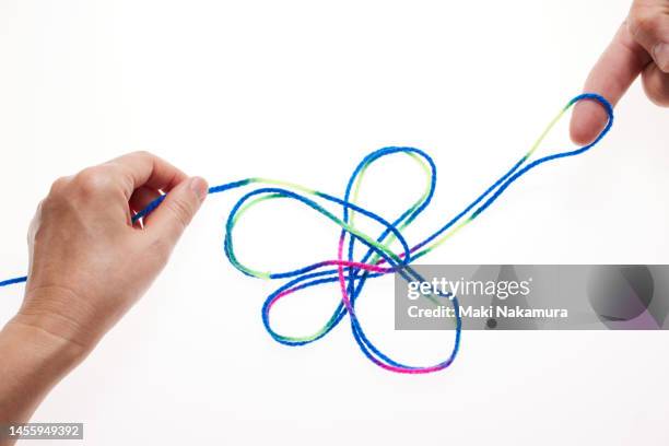 hands manipulating colorful threads. - 調布 stockfoto's en -beelden