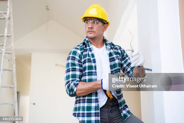 electrician with construction tools and electric drill. - dirty construction worker stock pictures, royalty-free photos & images