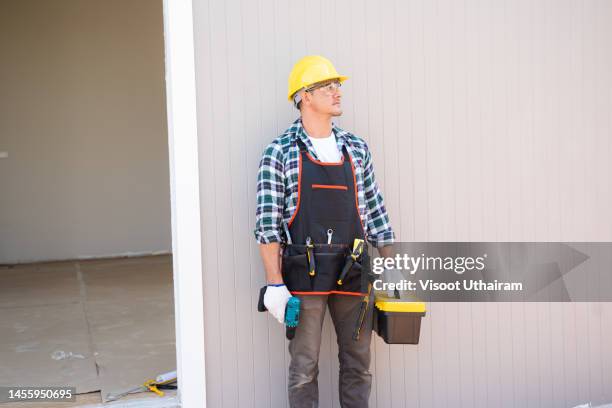 electrician installing electrical wiring in a new residential project. - cladding bildbanksfoton och bilder