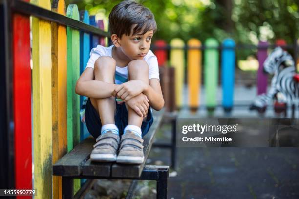 kid sitting on a bench and feeling lonely - only boys stock pictures, royalty-free photos & images