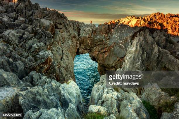a man with a dramatic landscape along the spanish coastline - llanes stock-fotos und bilder