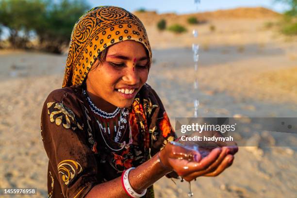 indian little girl drinking fresh water, desert village, rajasthan, india - mineral water stock pictures, royalty-free photos & images
