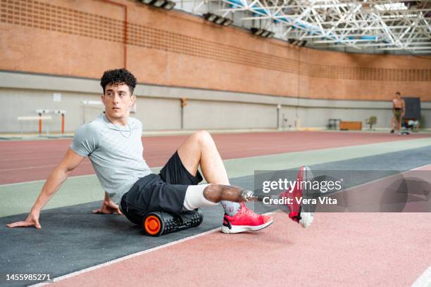 portrait of young man with prosthetic leg working out on sport stadium indoors. - vita shorts fotografías e imágenes de stock