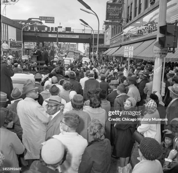 View over a crowd at 63rd Street and Halsted Street, of American religious and Civil Rights leader Dr Martin Luther King Jr as he speaks during a...