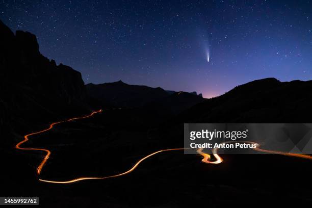 comet c/2022 e3 (ztf) over the road in the mountains at night - comet stock-fotos und bilder