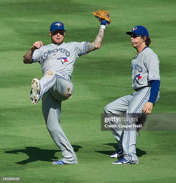 Brett Lawrie of the Toronto Blue Jays makes a leaping catch next to Colby Rasmus in a game against the Texas Rangers at Rangers Ballpark in Arlington...