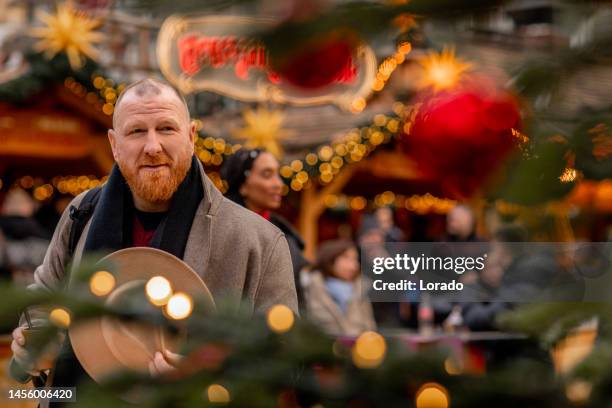 hübscher rothaariger mann auf einem deutschen weihnachtsmarkt - advent stock-fotos und bilder