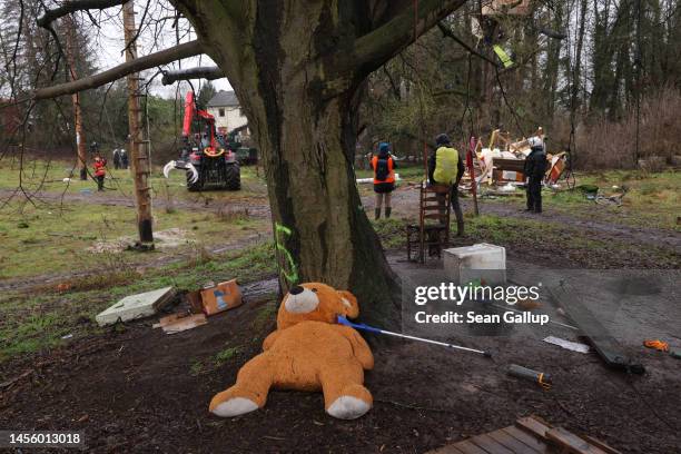 Giant teddy bear lies under a tree while police clear activists and demolish their structures at the settlement of Luetzerath on January 12, 2023...