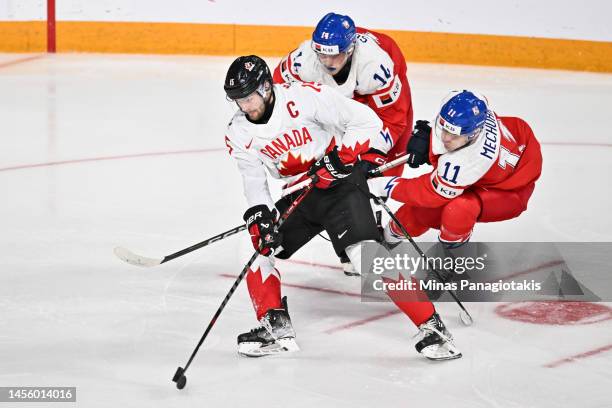 Shane Wright of Team Canada skates the puck past Stanislav Svozil and Adam Mechura of Team Czech Republic during the second period against Team Czech...