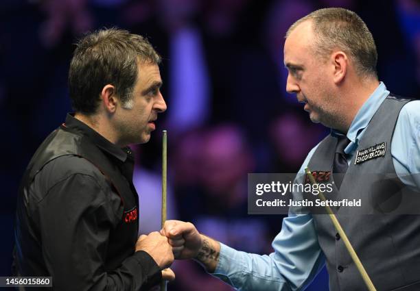 Mark Williams of Wales bumps fists with Ronnie O'Sullivan of England after winning their quarter final match against on Day Five of the Cazoo Masters...