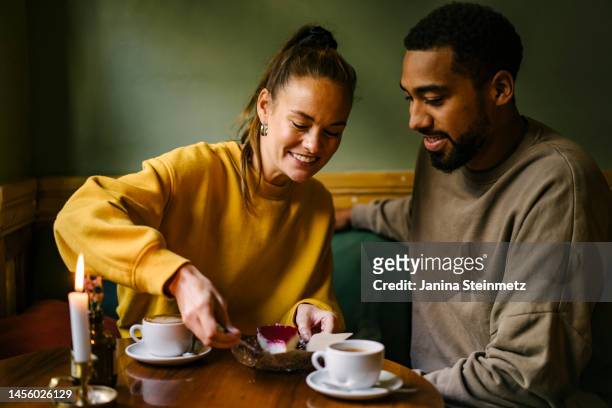 female enjoying raspberry dessert while boyfriend watches - dessert stock pictures, royalty-free photos & images