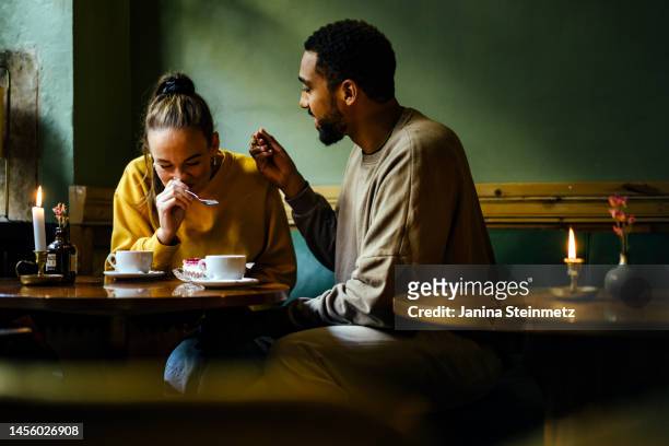 woman laughing while eating  at cafe - couple cuisine stock pictures, royalty-free photos & images