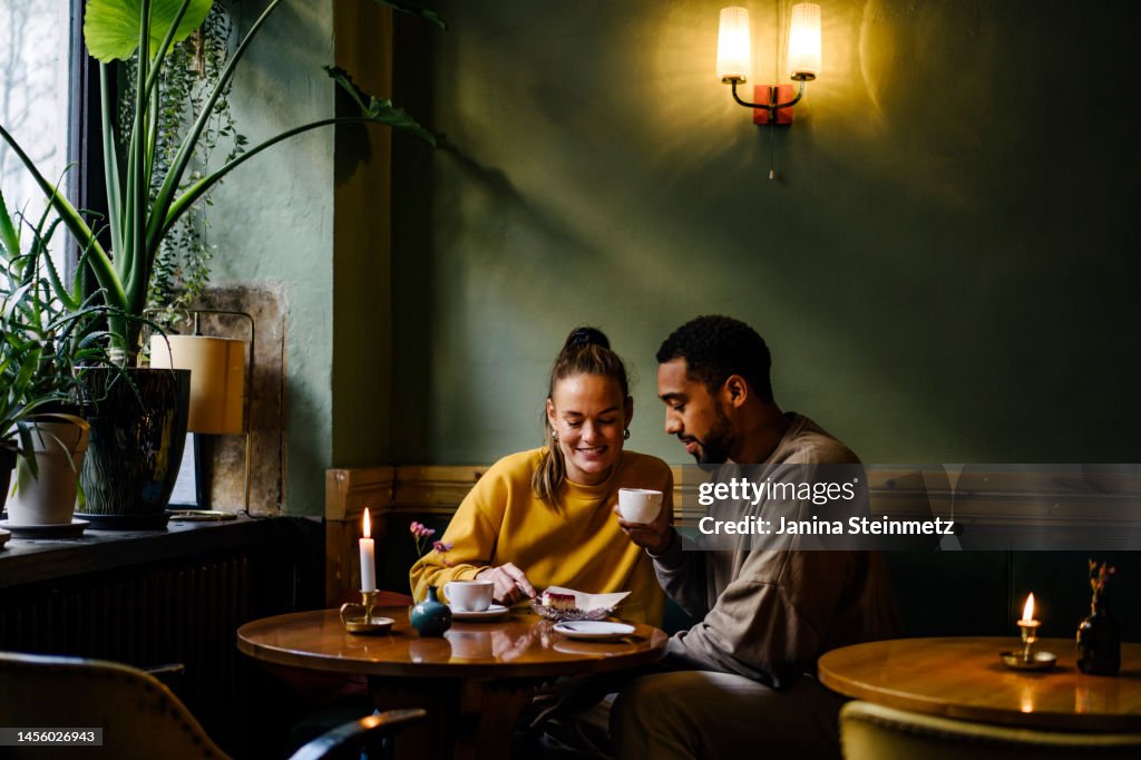 Wide shot with copy space of couple sharing a dessert in cafe