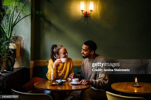 wide shot of couple having a conversation at a coffee shop - cortejar imagens e fotografias de stock
