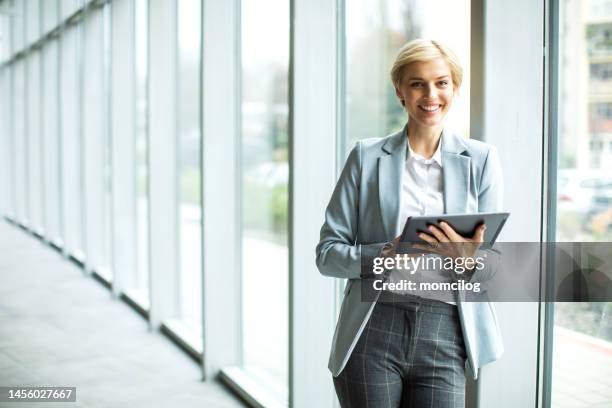 junge blonde geschäftsfrau arbeitet an einem digitalen tablet in einem modernen gebäude - portrait of cool creative businesswoman at office stock-fotos und bilder