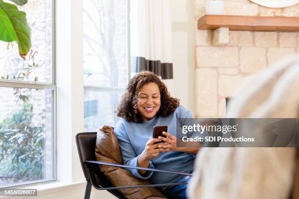 la madre casalinga ama navigare in rete sul telefono - persona di casa foto e immagini stock