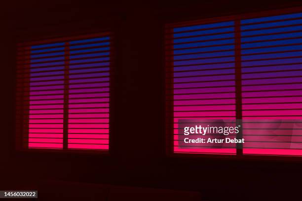dramatic sunset sky seen from the window blinds in a dark room. - window frame stock pictures, royalty-free photos & images