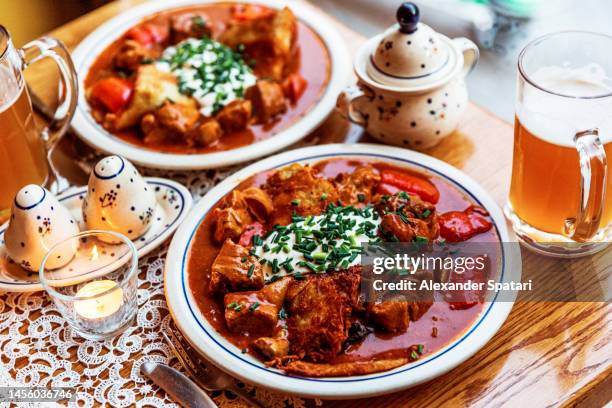 beef goulash served with potato pancake in a restaurant - cultura húngara fotografías e imágenes de stock