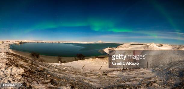 aurora borealis or northern lights the amazing wonder of nature in the dramatic skies of iceland. night landscape with the green light and the white snow of winter - back lit signage stock pictures, royalty-free photos & images