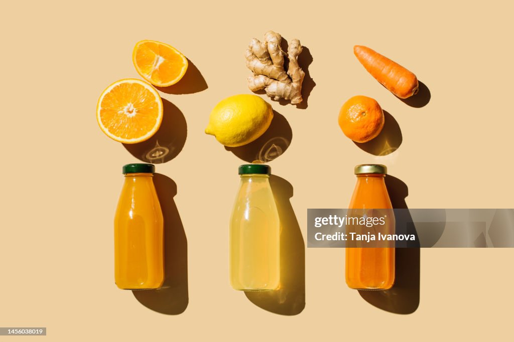 Various of colorful smoothies or juices bottles beverages drinks with various fresh ingredients: fruits and vegetables on beige background. Superfoods, healthy food, drinks, diet and detox concept. Flat lay, top view