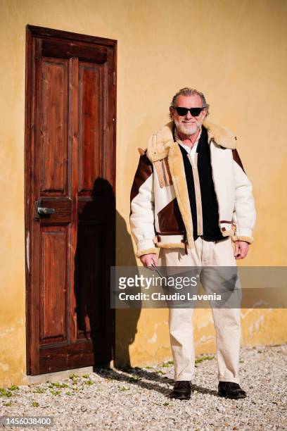 Alessandro Squarzi, wearing white pants and white and brown sheepskin jacket, is seen at Fortezza Da Basso on January 12, 2023 in Florence, Italy.