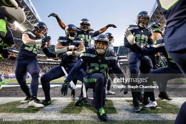 The Seattle Seahawks celebrate an interception by Quandre Diggs against the Los Angeles Rams during overtime at Lumen Field on January 08, 2023 in...