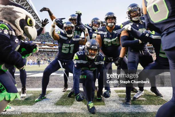 The Seattle Seahawks celebrate an interception by Quandre Diggs against the Los Angeles Rams during overtime at Lumen Field on January 08, 2023 in...