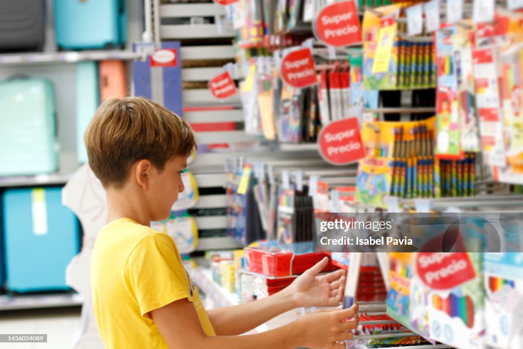 Boy shopping for school supplies in a supermarket
