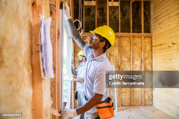 construction workers installing windows - replacement windows stock pictures, royalty-free photos & images