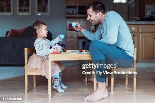 Toddler girl and dad toast while having tea party Toddler girl and dad toast while having tea party