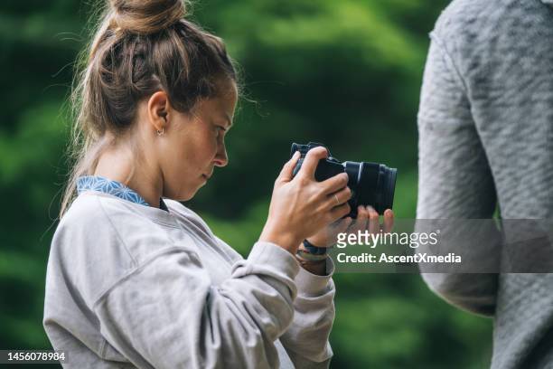 young woman uses digital camera outdoors - escape rom stock pictures, royalty-free photos & images
