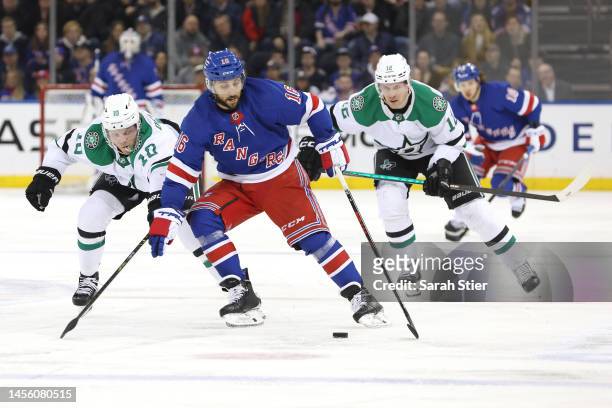 Vincent Trocheck of the New York Rangers controls the puck as Ty Dellandrea and Radek Faksa of the Dallas Stars defend during the second period at...